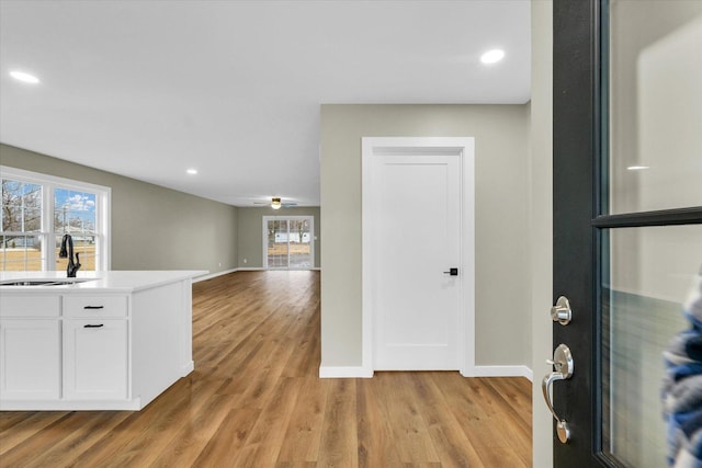 entrance foyer with ceiling fan, light hardwood / wood-style floors, sink, and a wealth of natural light