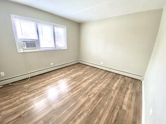 unfurnished room with hardwood / wood-style floors, cooling unit, and baseboard heating