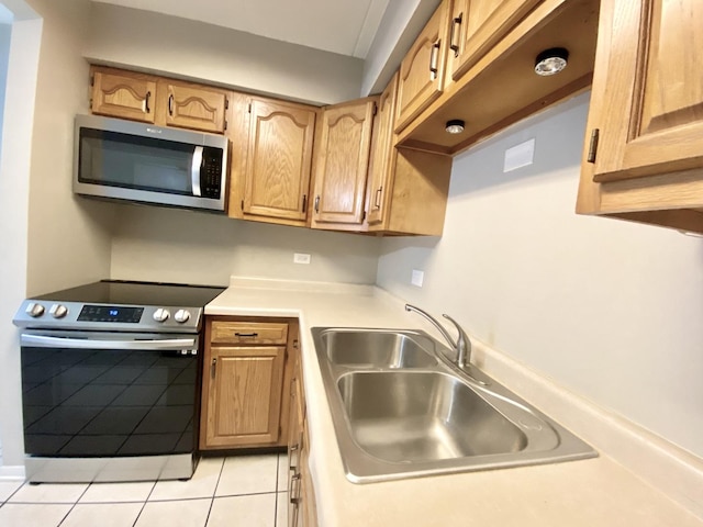 kitchen with sink, light tile patterned flooring, and stainless steel appliances