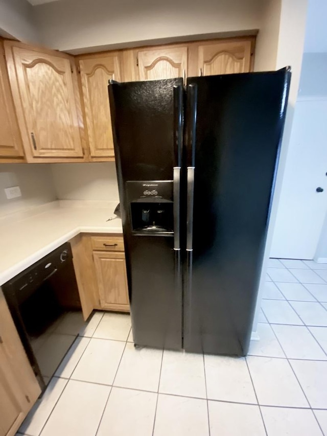 kitchen with light tile patterned flooring, light brown cabinetry, and black appliances