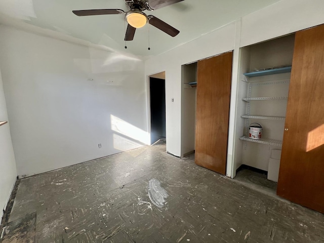 unfurnished bedroom with ceiling fan and two closets