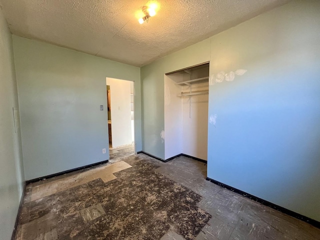 unfurnished bedroom featuring a textured ceiling and a closet