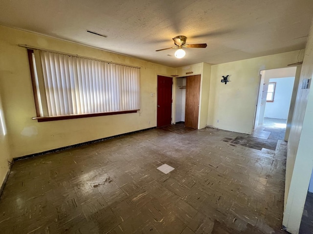 unfurnished room with a textured ceiling and ceiling fan