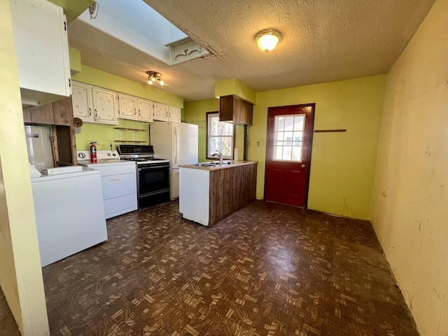 kitchen featuring a textured ceiling, white cabinetry, washer and clothes dryer, and white appliances