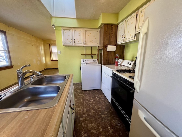 kitchen with a textured ceiling, sink, white appliances, and washer / dryer