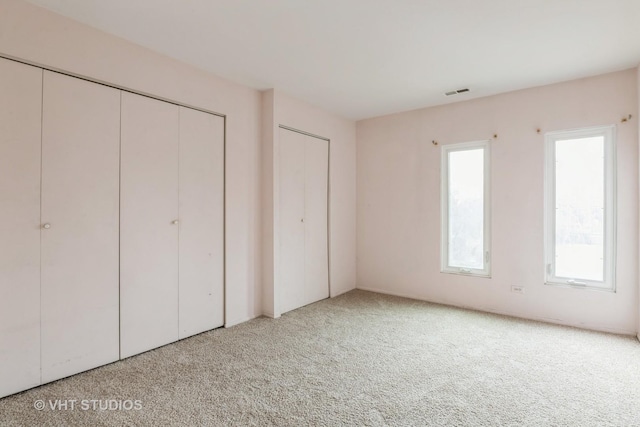 unfurnished bedroom featuring visible vents and carpet flooring