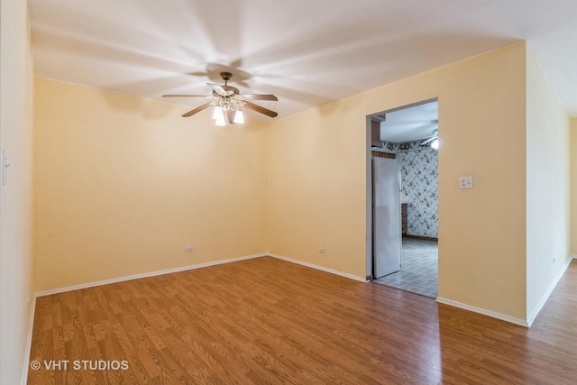 unfurnished room with a ceiling fan, baseboards, and wood finished floors