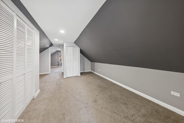 additional living space with carpet flooring and lofted ceiling