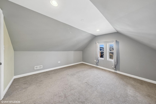 additional living space featuring carpet flooring and lofted ceiling