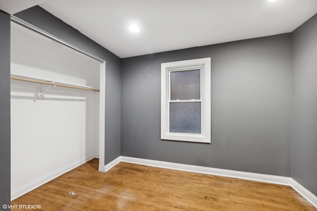 unfurnished bedroom featuring a closet and hardwood / wood-style floors