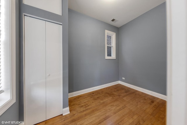 unfurnished bedroom with hardwood / wood-style flooring and a closet