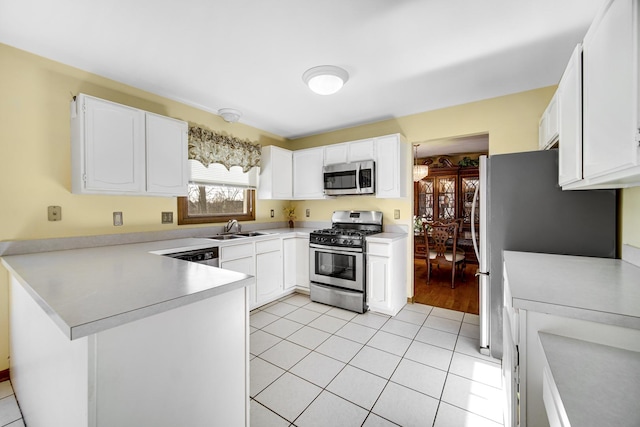 kitchen featuring white cabinets, light tile patterned floors, stainless steel appliances, and kitchen peninsula