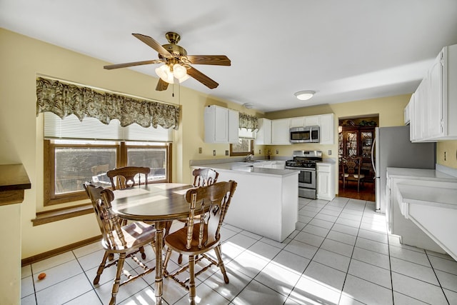 kitchen with light tile patterned floors, stainless steel appliances, and white cabinets