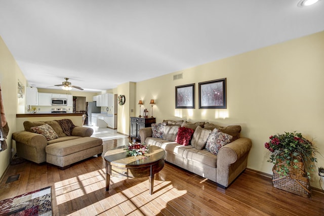 living room featuring light wood-type flooring and ceiling fan