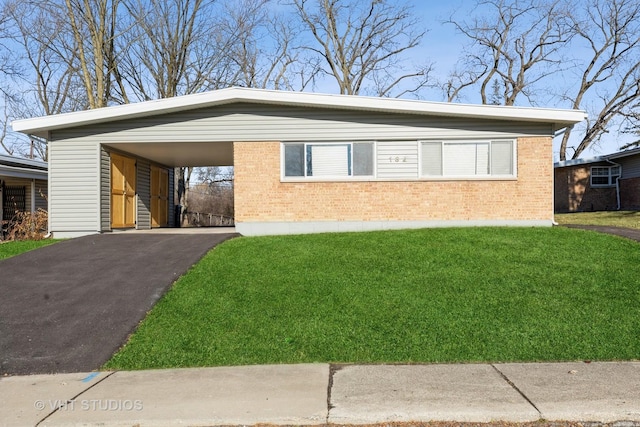 view of front of home with a carport and a front lawn