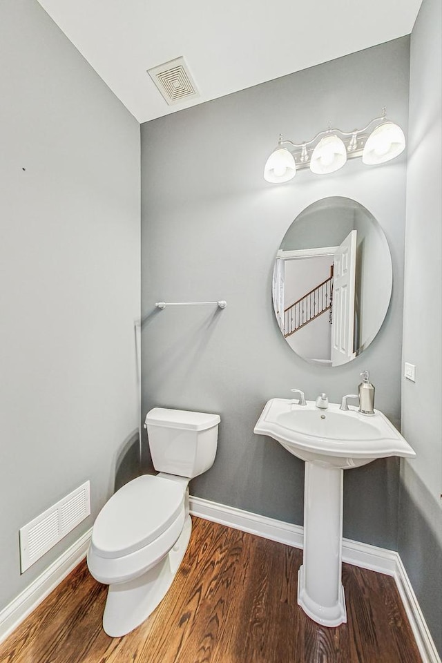 bathroom with hardwood / wood-style floors and toilet