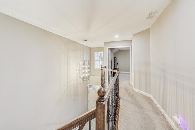 hall featuring a chandelier and light carpet