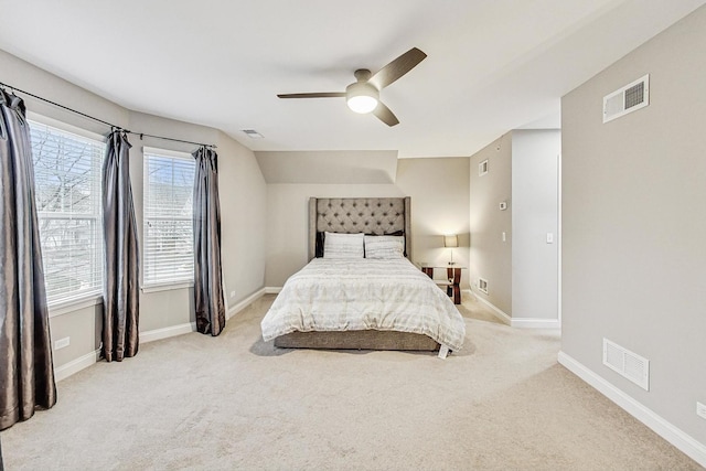 bedroom with ceiling fan, light colored carpet, and vaulted ceiling