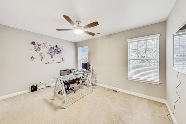 carpeted office space featuring ceiling fan