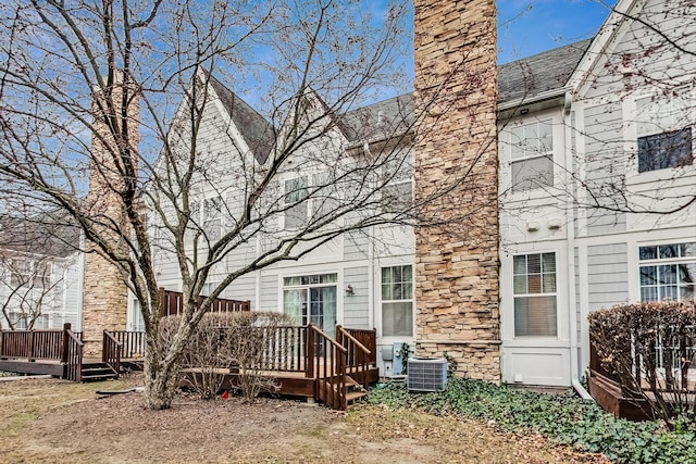 rear view of property with cooling unit and a wooden deck