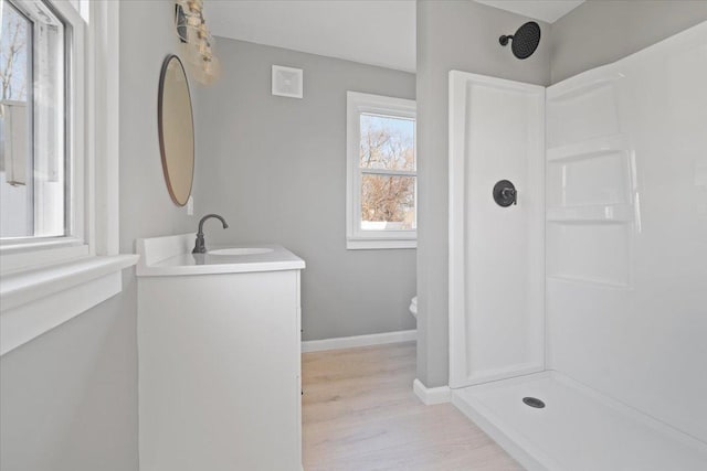 bathroom featuring vanity, hardwood / wood-style flooring, toilet, and walk in shower