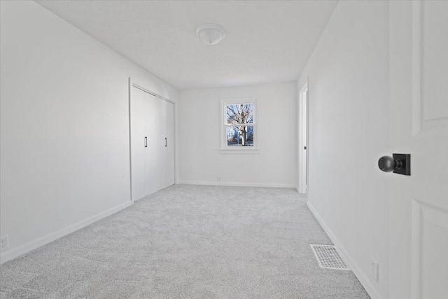 unfurnished room featuring light carpet