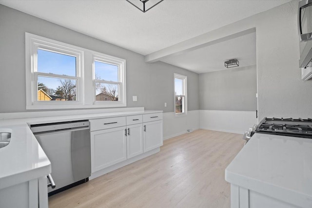 kitchen with light hardwood / wood-style floors, white cabinetry, a textured ceiling, and appliances with stainless steel finishes