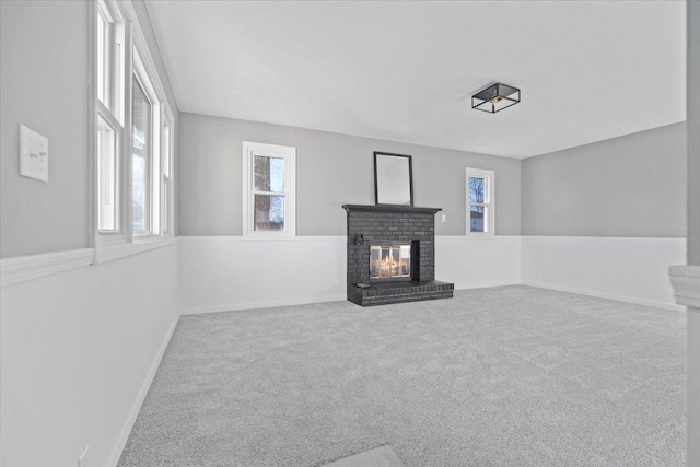 unfurnished living room with carpet flooring and a fireplace