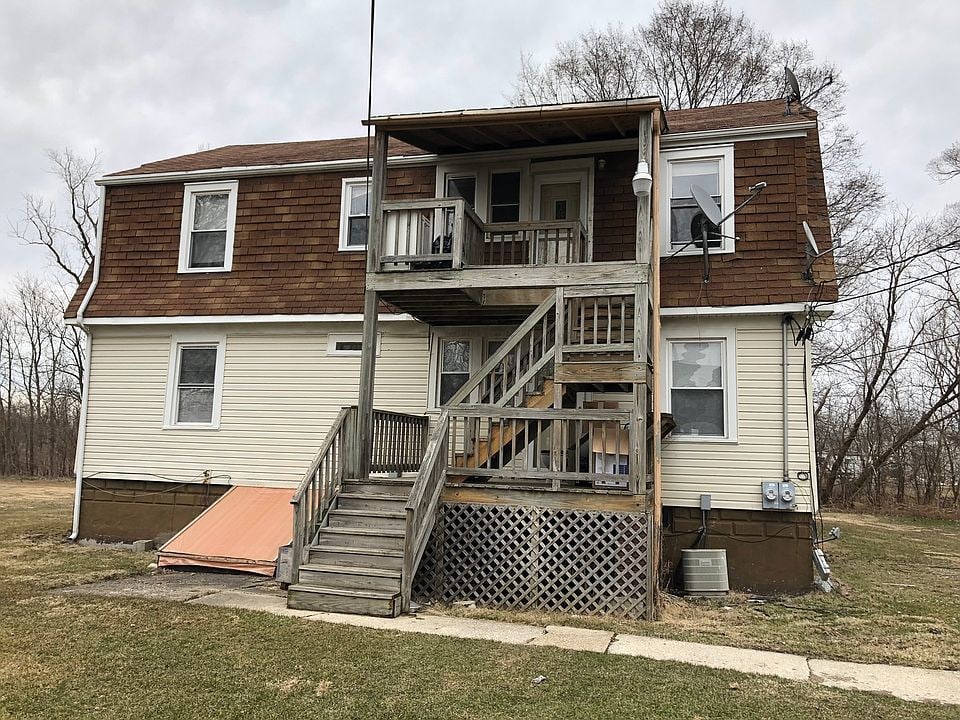 back of house featuring a yard and central AC unit