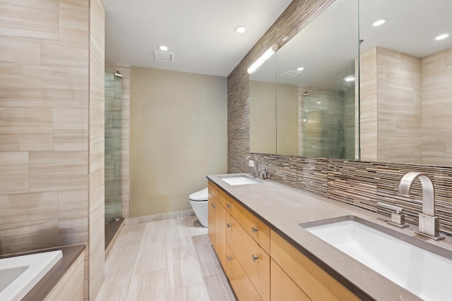 full bathroom featuring vanity, decorative backsplash, toilet, tile walls, and independent shower and bath