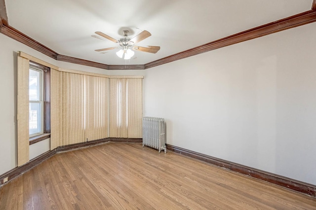 spare room featuring hardwood / wood-style flooring, ceiling fan, radiator heating unit, and ornamental molding