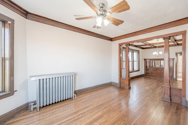 spare room with beamed ceiling, light wood-type flooring, radiator, and ornamental molding