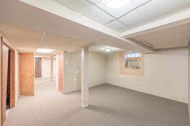 basement featuring a drop ceiling and carpet