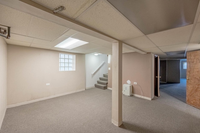 basement featuring a drop ceiling and carpet