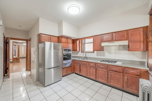 kitchen with light tile patterned flooring, radiator heating unit, stainless steel appliances, and sink