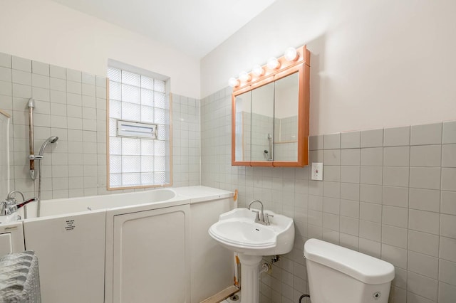 bathroom featuring a healthy amount of sunlight, tile walls, and a tub