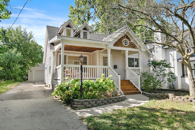 view of front facade with a porch, an outbuilding, and a garage