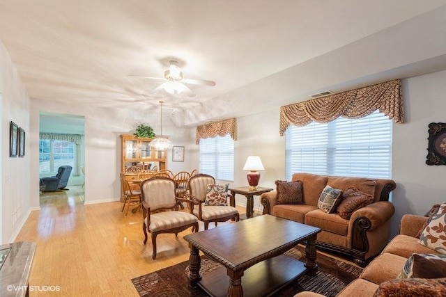 living room with ceiling fan and light wood-type flooring