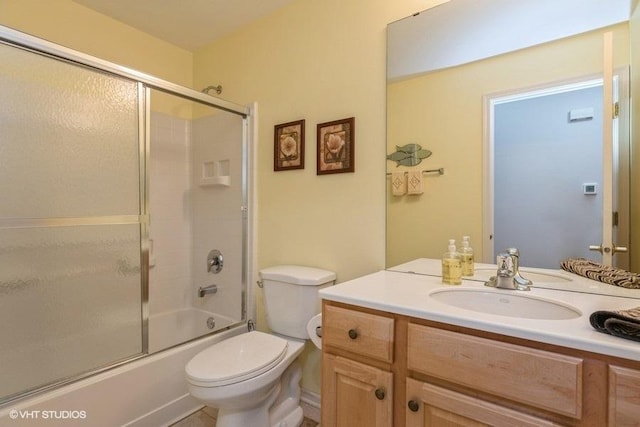 full bathroom featuring vanity, enclosed tub / shower combo, and toilet