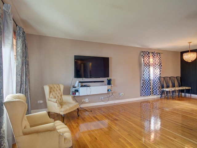 living area featuring hardwood / wood-style floors and an inviting chandelier