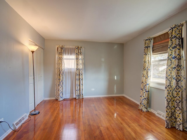 empty room with wood-type flooring and plenty of natural light