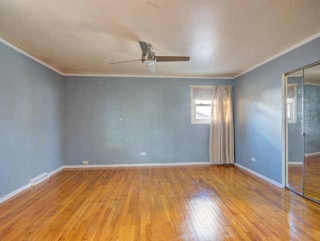 spare room with crown molding, ceiling fan, and light wood-type flooring