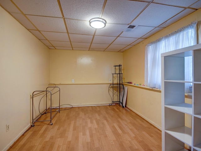 spare room with wood-type flooring and a paneled ceiling