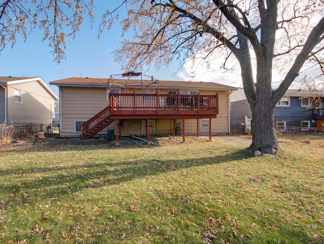 rear view of house with a lawn and a wooden deck