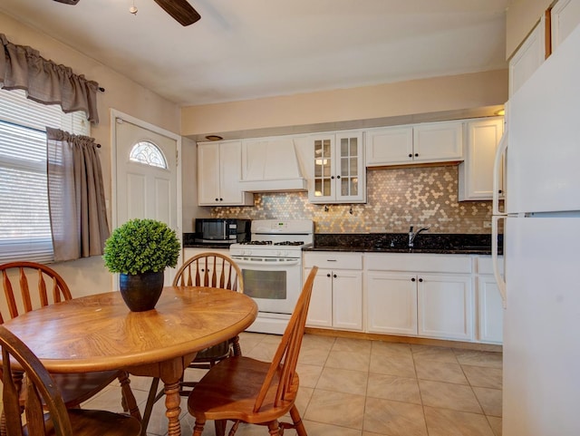 kitchen with white appliances, premium range hood, sink, tasteful backsplash, and white cabinetry