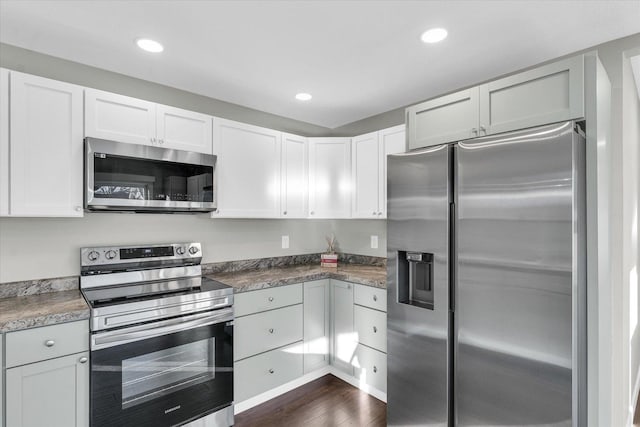 kitchen with white cabinets, dark hardwood / wood-style floors, and appliances with stainless steel finishes