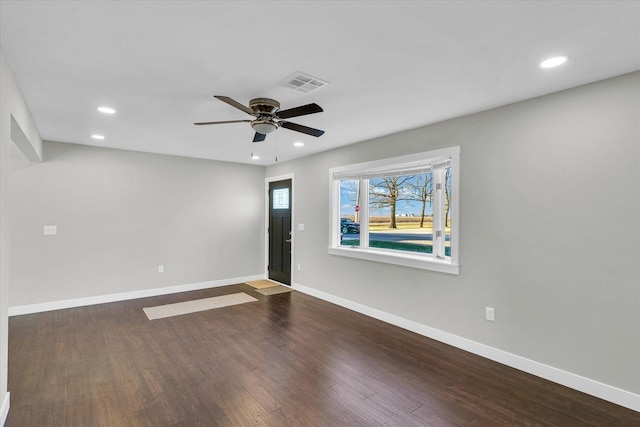 unfurnished room featuring ceiling fan and dark wood-type flooring