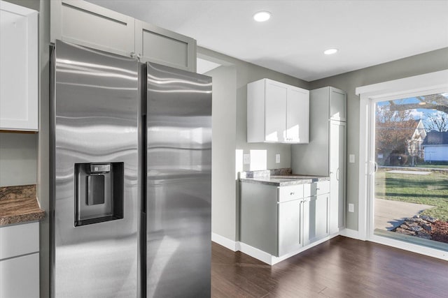 kitchen with white cabinets, stainless steel fridge, dark stone countertops, and dark wood-type flooring