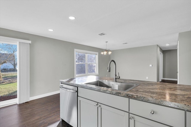 kitchen with dishwasher, dark wood-type flooring, sink, hanging light fixtures, and a notable chandelier