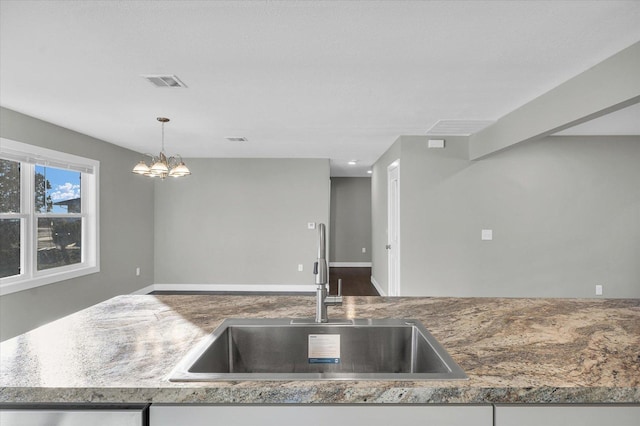 kitchen with pendant lighting, sink, and a chandelier